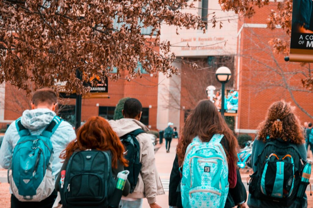pexels photo 1454360 A group of college students with backpacks walking together outdoors on campus.